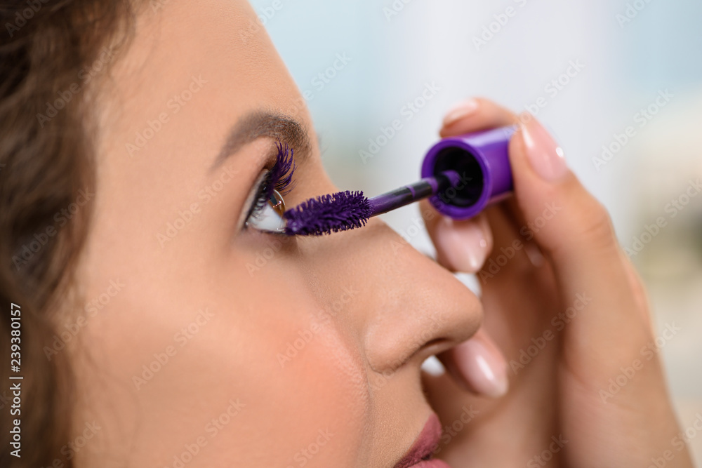 Woman with long eyelashes during makeup in salon.