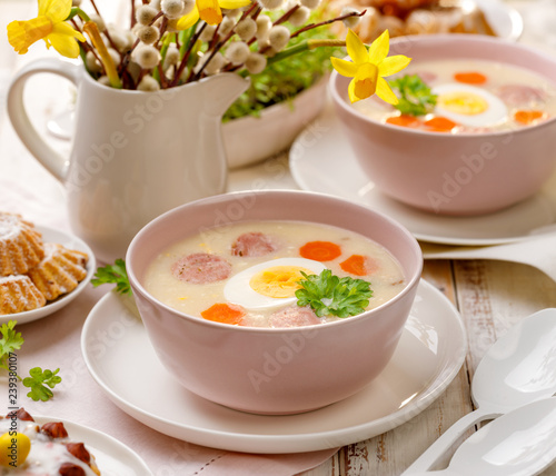White borscht, polish Easter soup with the addition of white sausage and a hard boiled egg in a ceramic bowl. Traditional Easter dish in Poland