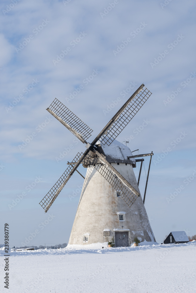 Grain mill on the winter landscape. Dutch windmill and natural background pattern