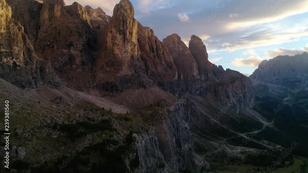 Dolomiti mountain peaks, C4k aerial, rising, drone shot, of a row of alpine tops, near Puez odle national park, on Gardena pass, on a sunny, summer evening sunset, in Dolomites, Tyrol, Italy Dolomiti mountain peaks, C4k aerial, rising, drone shot, of a row of alpine tops, near Puez odle national park, on Gardena pass, on a sunny, summer evening sunset, in Dolomites, Tyrol, Italy
