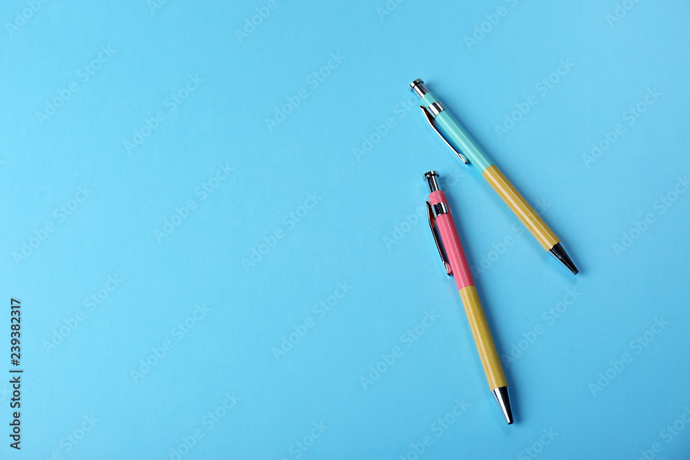 Bright pens on color background, flat lay. Space for text