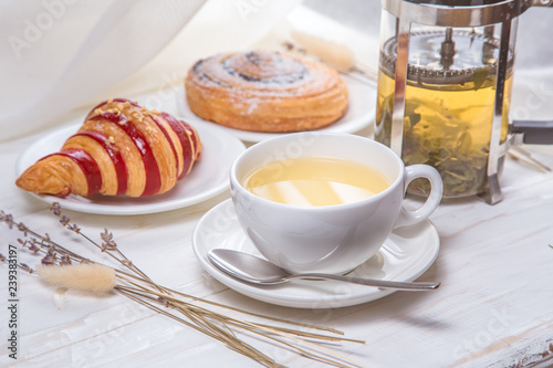 green tea with croissants on white wooden background