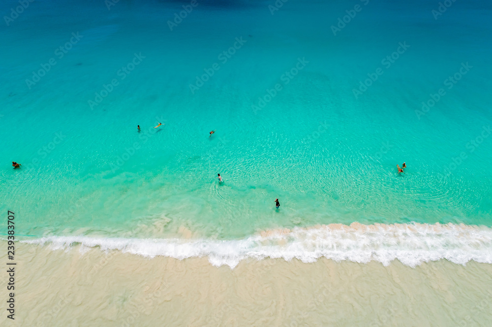 Obraz premium Aerial view of sandy beach with tourists swimming in beautiful clear sea water