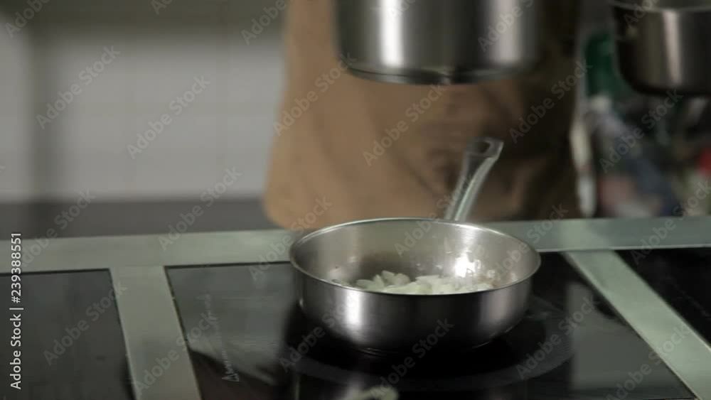 the cook heat up a frying pan in a restaurant kitchen the cook heat up a frying pan in a restaurant kitchen