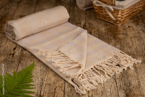 Handwoven hammam Turkish cotton towel on wooden background