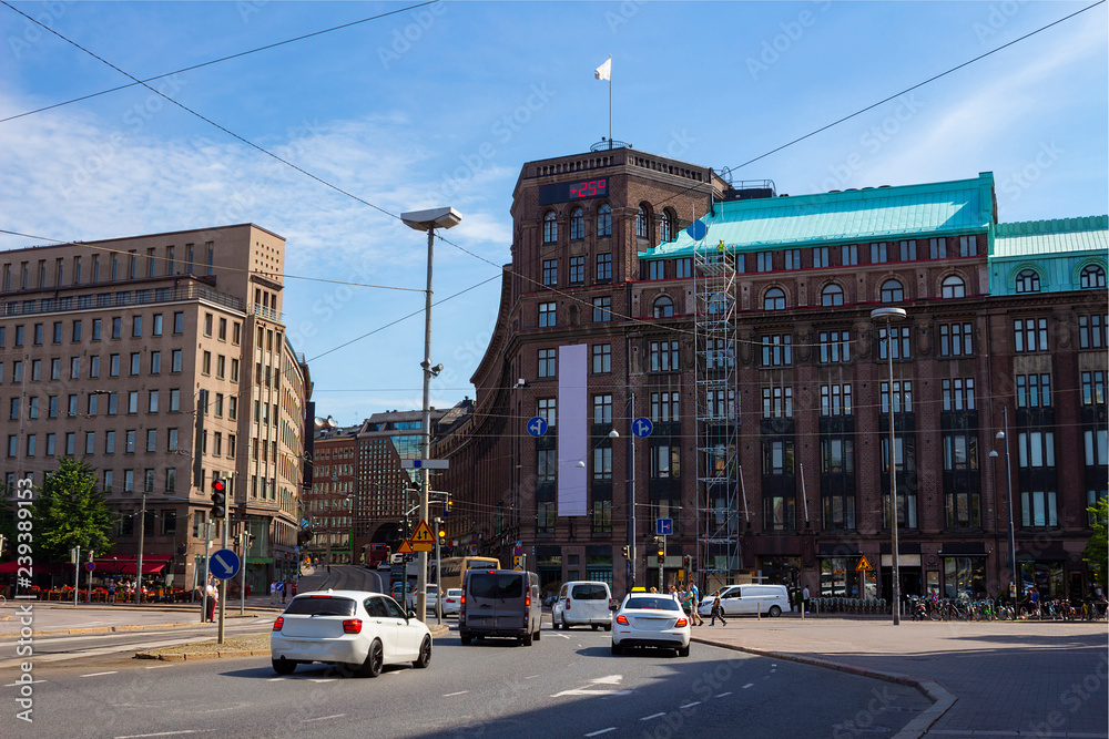 Fototapeta premium Square in the center of the city of Helsinki the capital of Finland on a hot summer day. The display on the building shows +25 degrees Celsius.