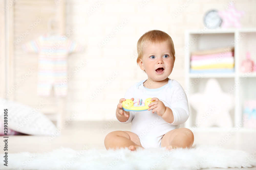 Baby boy with toys sitting on carpet at home Baby boy with toys sitting on carpet at home
