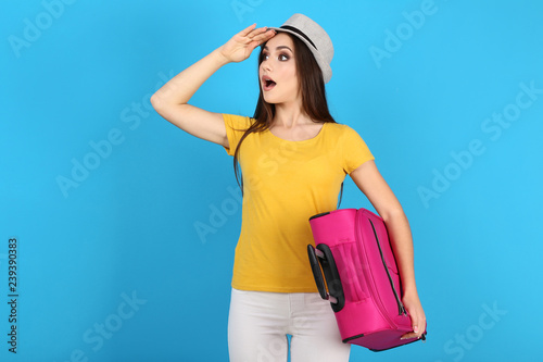 Young girl with suitcase on blue background