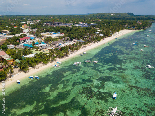 Aerial drone view of Alona beach at Panglao island. Beautiful tropical island landscape with traditional boats, sand beach and palm trees. Bohol, Philippines. photo