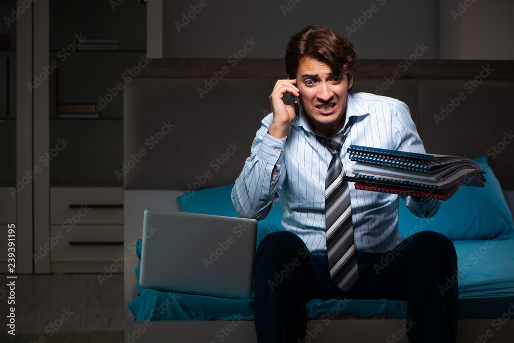 Tired businessman working overtime at home at night