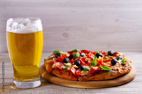 Glass of beer and pizza on wooden table. Beer and food concept. Ale. Copy space
