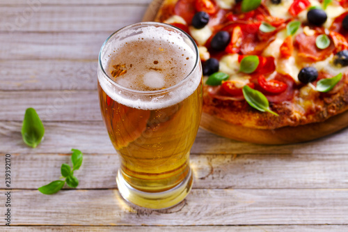 Glass of beer and pizza on wooden table. Beer and food concept. Ale.