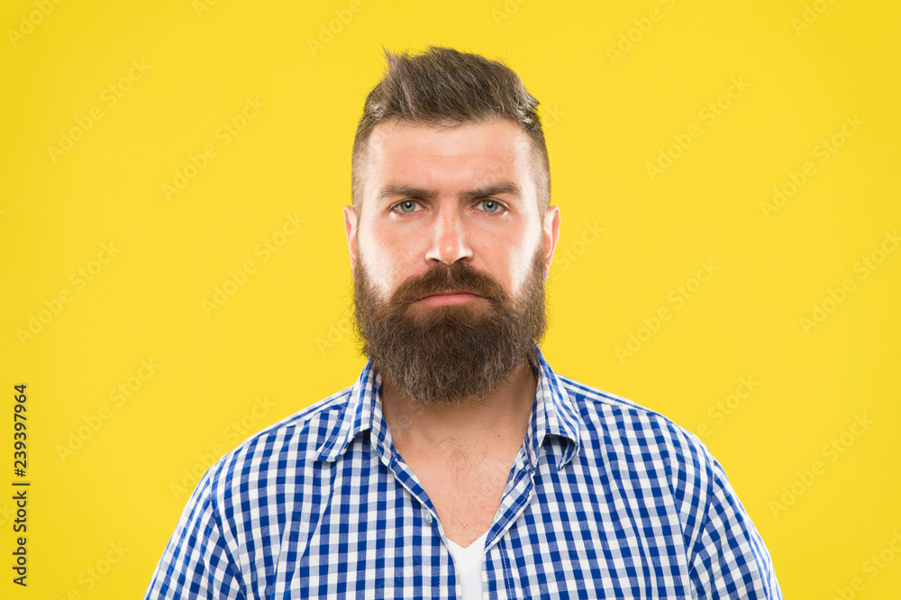 Obraz premium Bearded and serious. Beard fashion and barber concept. Man bearded rustic hipster stylish beard yellow background. Barber tips maintain beard. Stylish beard and mustache care. Hipster appearance