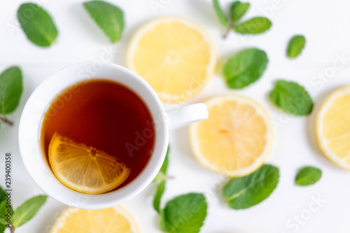 A cup of tea along with mint and lemon. Tea for colds. Natural cures for the disease. Vitamin C. Black tea with lemon on a white background