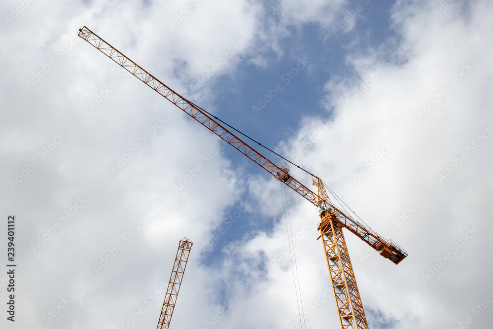 two cranes against blue sky and white clouds two cranes against blue sky and white clouds