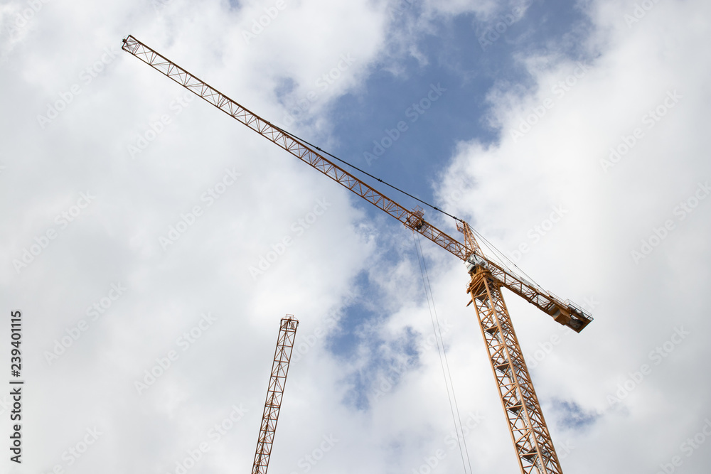 two cranes against blue sky and white clouds two cranes against blue sky and white clouds