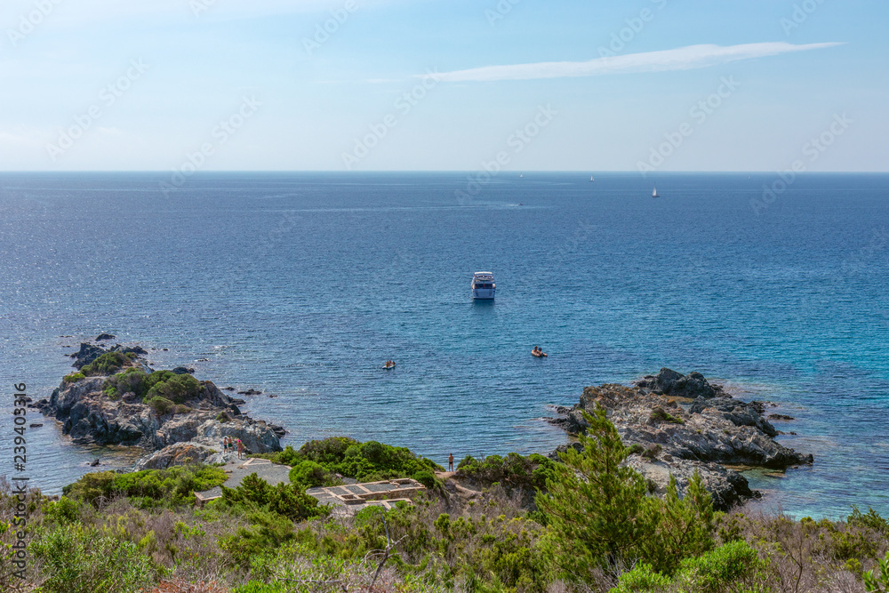 Beautiful view of the rocky shore of Elba Island, blue sea and boats. Elba island, Tuscany, Italy Beautiful view of the rocky shore of Elba Island, blue sea and boats. Elba island, Tuscany, Italy