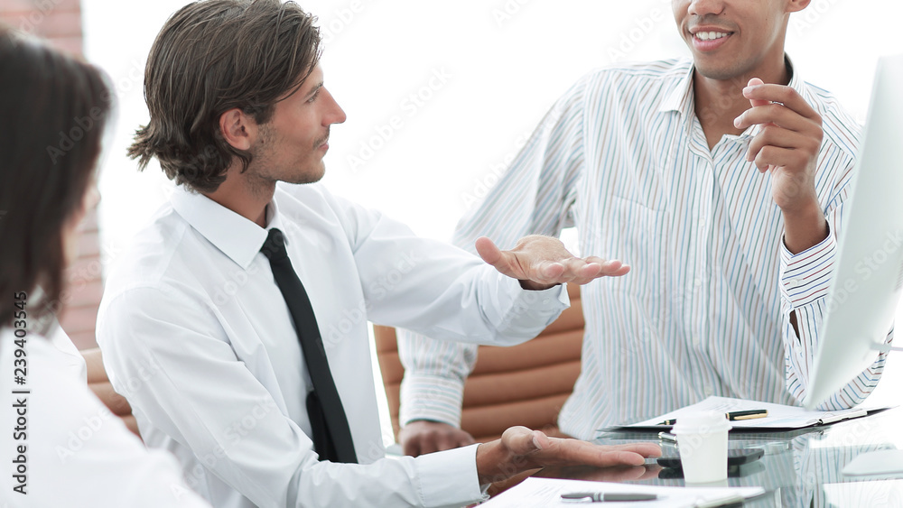 businessman talking to a business team sitting at Desk. businessman talking to a business team sitting at Desk.