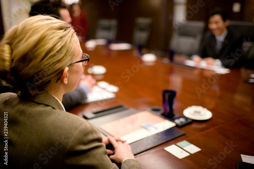Business woman sitting with colleagues in a boardroom. photo