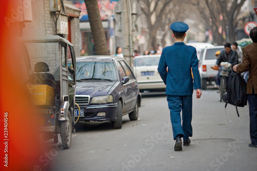 Wallpaper Mural Uniformed man walking down a street in the city. Torontodigital.ca