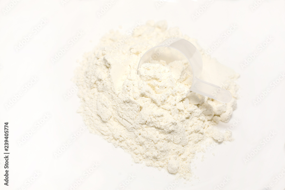 heap of whey protein powder with plastic spoon on white background