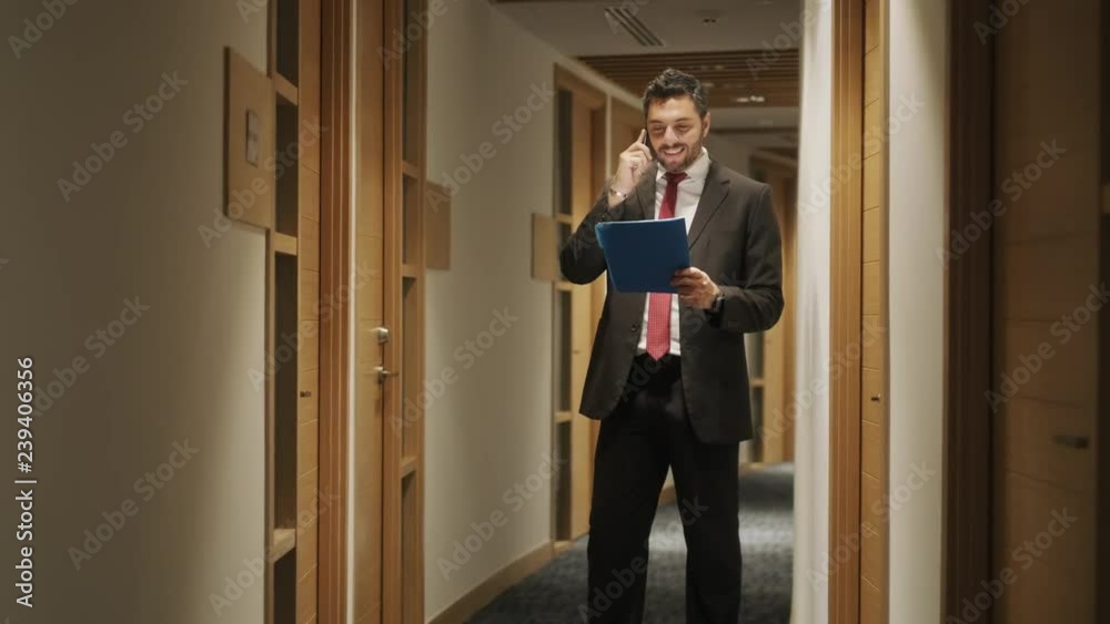 Portrait of happy businessman working in office, financial consultant talking on mobile telephone. Happy bank manager speaking with smartphone, young business man smiling with cell phone. Slow motion Portrait of happy businessman working in office, financial consultant talking on mobile telephone. Happy bank manager speaking with smartphone, young business man smiling with cell phone. Slow motion