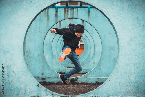 Fototapeta Young Asian active man jumping and kicking action, circle looping wall background
