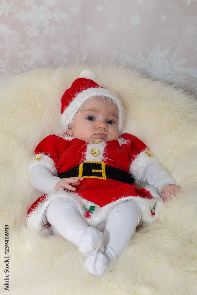 Fototapeta premium baby in santa claus hat sitting on fur