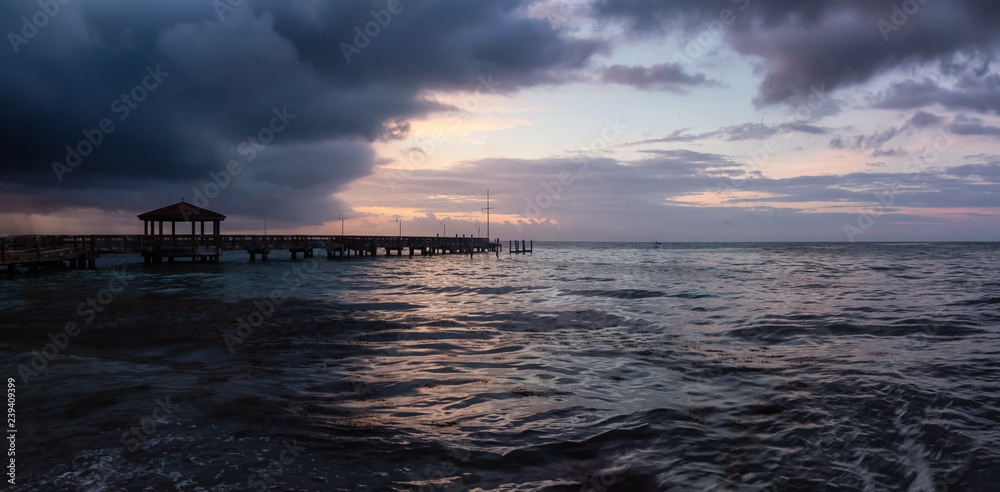 Obraz premium Panoramic seascape view of the Atlantic Ocean Coast during a dramatic cloudy sunrise. Taken in Key West, Florida Keys, United States.