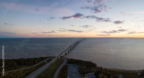 Aerial Panoramic view of Confederation Bridge to Prince Edward Island during a vibrant sunny sunrise. Taken in Cape Jourimain National Wildlife Area, New Brunswick, Canada. photo