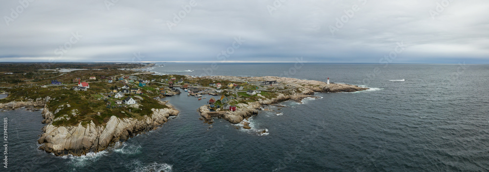 Aerial panoramic view of a small town near a rocky coast on the Atlantic Ocean. Taken in Peggy Cove, near Halifax, Nova Scotia, Canada.
