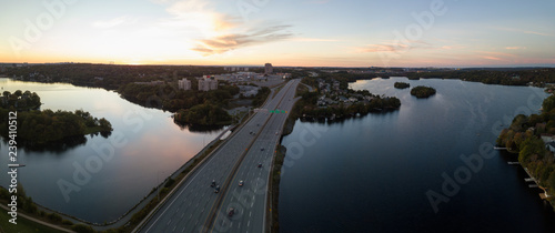 Aerial panoramic view of a Highway in the Modern City during a vibrant Sunset. Taken in Halifax, Dartmouth, Nova Scotia, Canada.