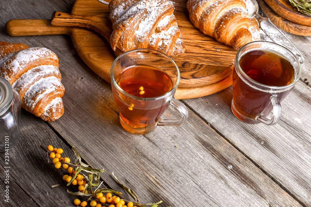 Fresh croissants sprinkled with nuts and a cup of black coffee Fresh croissants sprinkled with nuts and a cup of black coffee