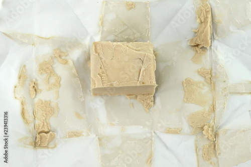 Baker's yeast isolated on white background. A block of compressed fresh yeast isolated.