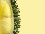 Fresh cut durian on pastel yellow background, king of fruit from Thailand, close up with copy space