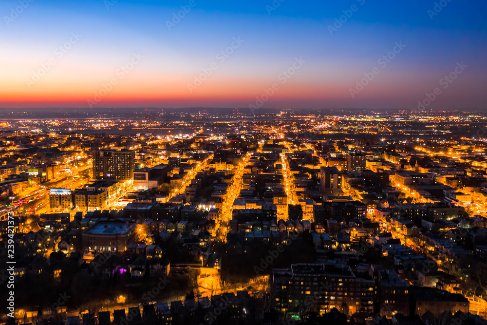Aerial view of Hoboken, New Jersey at dusk, with illuminated streets converging towards the horizon