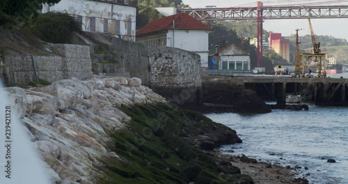 Old city docks of Almada with view to the Lisbon Bridge (Ponte 25 de Abril). Shot at a seawall were fisherman usually go fishing. Located near the capital of Portugal, Lisbon photo