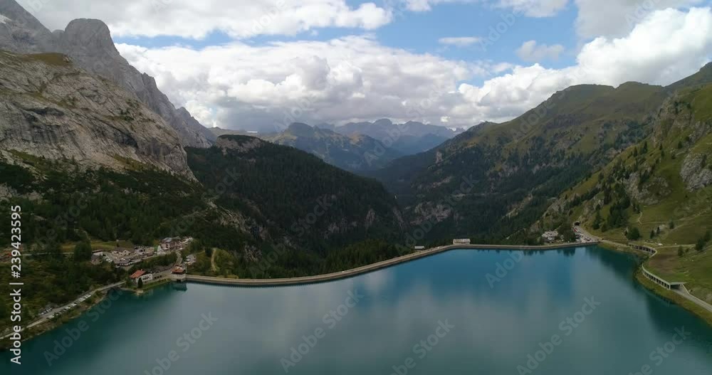 Dolomites lake, C4k aerial, rising, tilt down, drone shot, over a lago di fedaia, towards the dam, on Marmolada mountain, on a sunny, summer day, at Fedaia pass, in Dolomiti, Tyrol, Italy Dolomites lake, C4k aerial, rising, tilt down, drone shot, over a lago di fedaia, towards the dam, on Marmolada mountain, on a sunny, summer day, at Fedaia pass, in Dolomiti, Tyrol, Italy