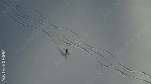 Drone tracking skier going down vast powder slope