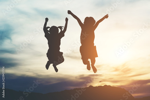 Silhouette of two girl having fun in nature