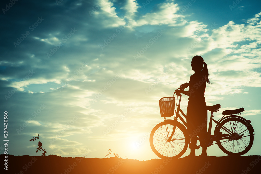 Silhouette of women with bicycle and beautiful sky