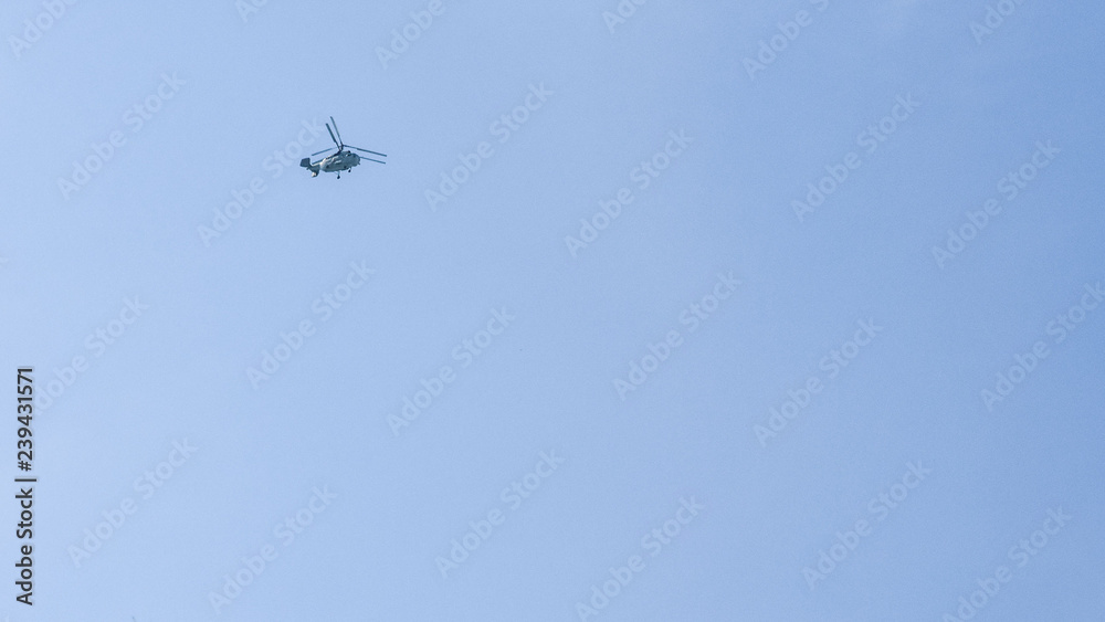 small silhouette of a helicopter on a background of clean blue sky. copy space for text small silhouette of a helicopter on a background of clean blue sky. copy space for text