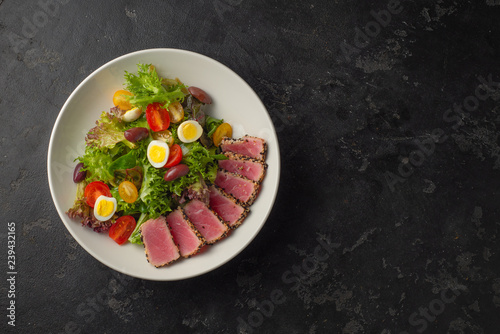 Sliced Steak of tuna in sesame and a salad of fresh vegetables and quail eggs.
