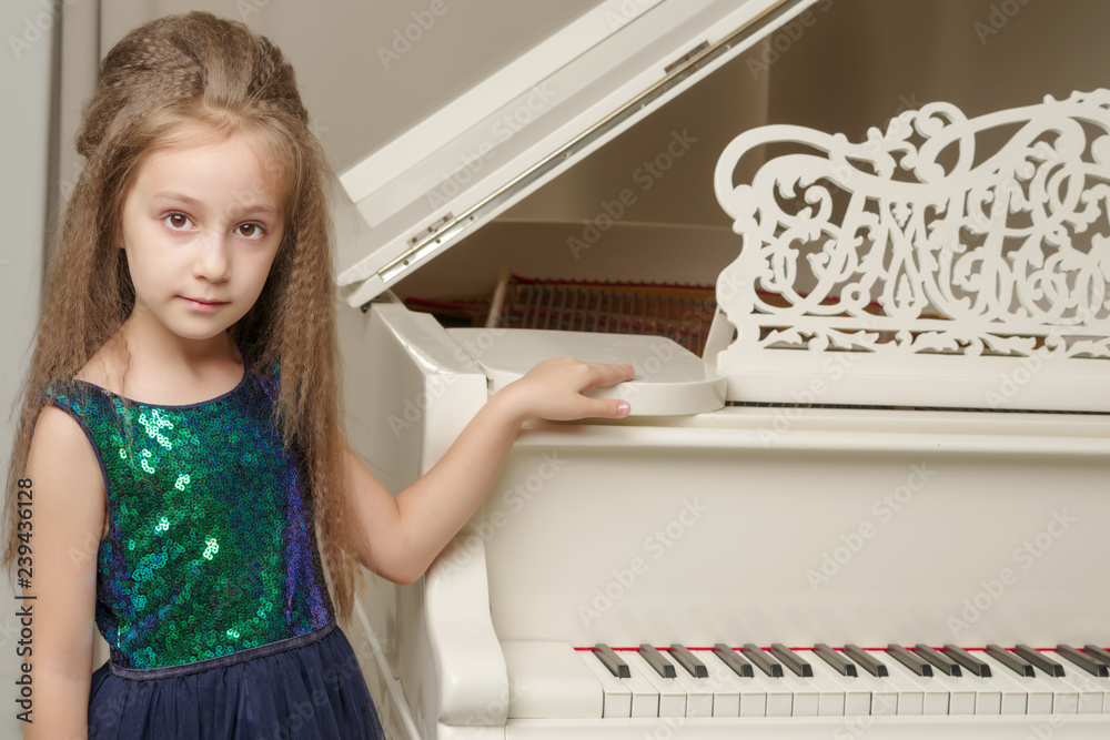 The girl is at the white grand piano. The girl is at the white grand piano.