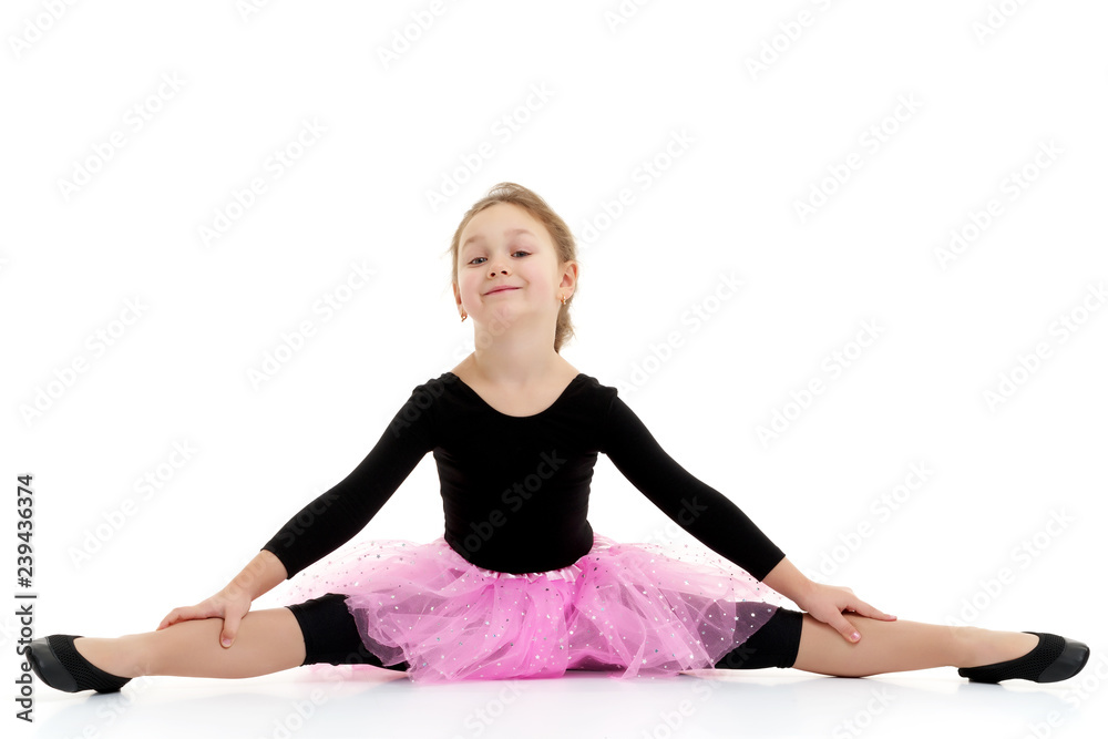 The little gymnast perform an acrobatic element on the floor. The little gymnast perform an acrobatic element on the floor.