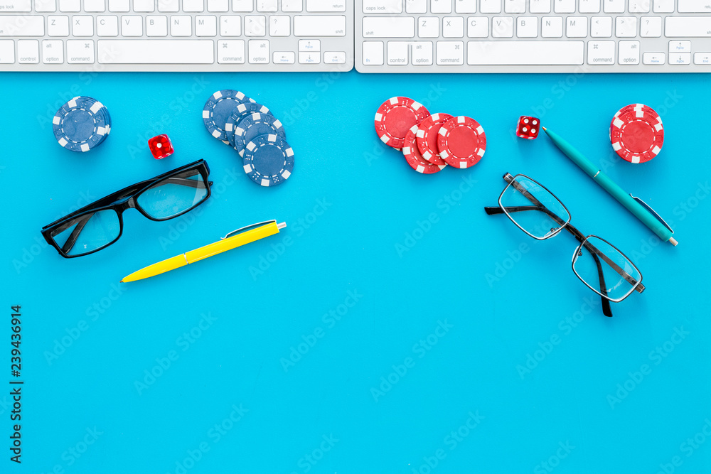 Business monopoly. Work desk with keyboard glasses, pens and stacks of chips. Competition. Blue desk background top view mock-up