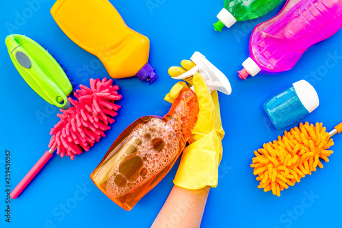 Housekeeping set. Detergents, soap, cleaners and brush for housecleaning on blue background top view mock-up