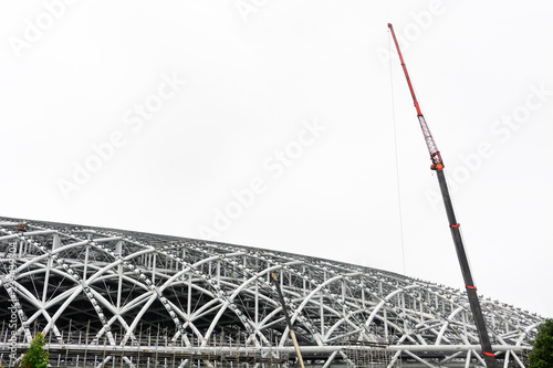 large crane on the  metal framework of stadium roof, the construction of new sport arena, isolated on white background, copy space photo