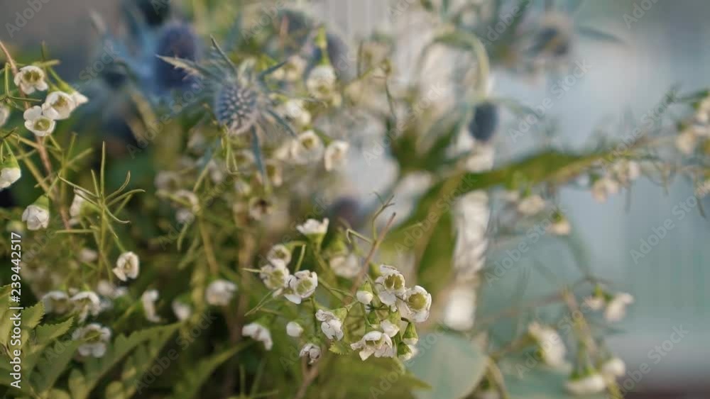 Close up of summer flowers in designs at an outdoor summer wedding reception