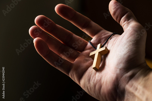 Man Holding a Simple Wood Cross in the Morning.